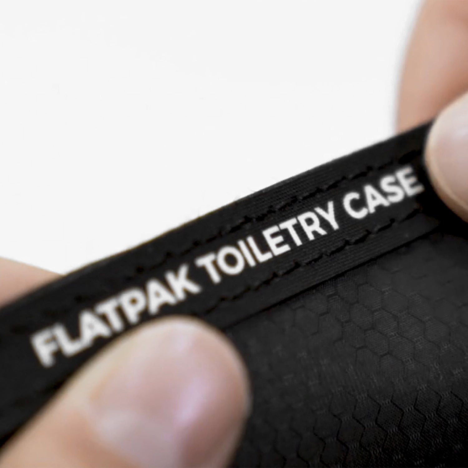Close up view of the words "FlatPak Toiletry Case" on a seam